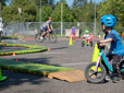 Children riding bicycles through an obstacle course at a bike rodeo event in Gresham